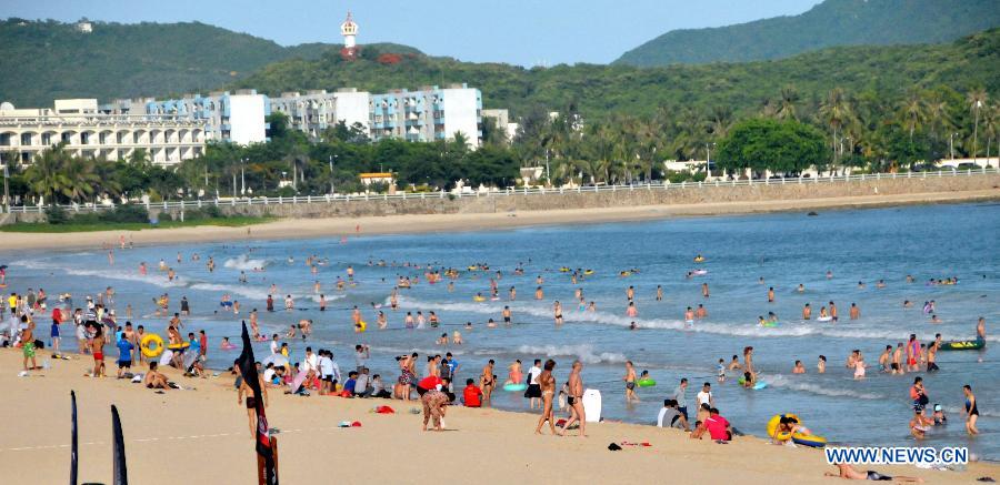 Tourists are seen at Dadonghai Beach in Sanya, south China's Hainan Province, June 20, 2013. People took actions to keep away from heat as the temperature in Sanya reached 30 degrees centigrade above recently. (Xinhua/Zhang Yongfeng)