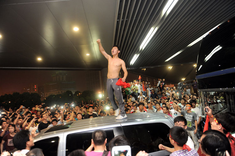 Behaving aggressively: After the most humiliating defeat for years for China's national soccer team as they lost 5-1 to visiting Thailand team on June 15, 2013, their bus was beset by Chinese fans. (Photo/Osports)