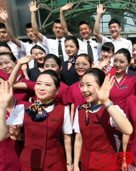 Wearing the uniforms of different airlines, graduates pose for photo on campus on June 19, 2013. (Xinhua/Liu Yuedong)