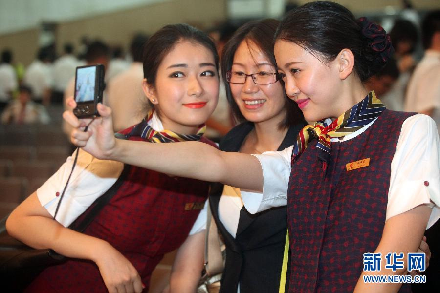 Two graduates and their teacher (middle) pose for photo at the graduation ceremony on June 19, 2013. (Xinhua/Liu Yuedong)