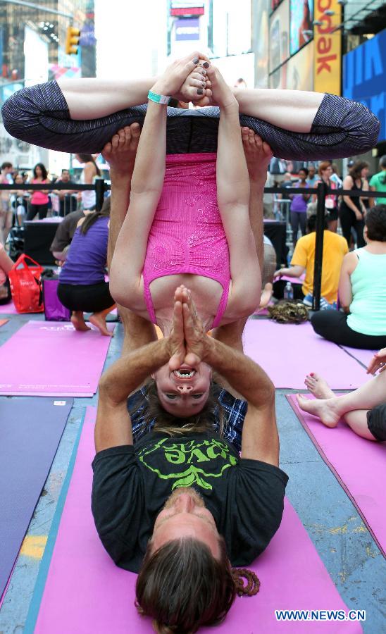 Yoga enthusiasts practice yoga during the "Solstice in Times Square" event at Times Square in New York, the United States, June 21, 2013. Thousands of yoga enthusiasts came here to do yoga in celebration of the longest day of the year. (Xinhua/Cheng Li) 