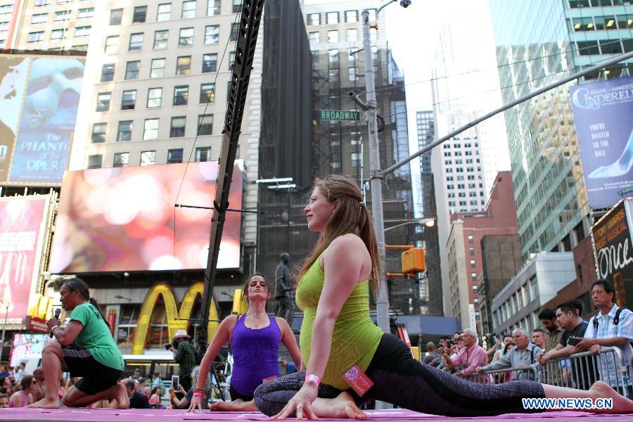 A pregnant Yoga enthusiast (R) practices yoga during the "Solstice in Times Square" event at Times Square in New York, the United States, June 21, 2013. Thousands of yoga enthusiasts came here to do yoga in celebration of the longest day of the year. (Xinhua/Cheng Li) 