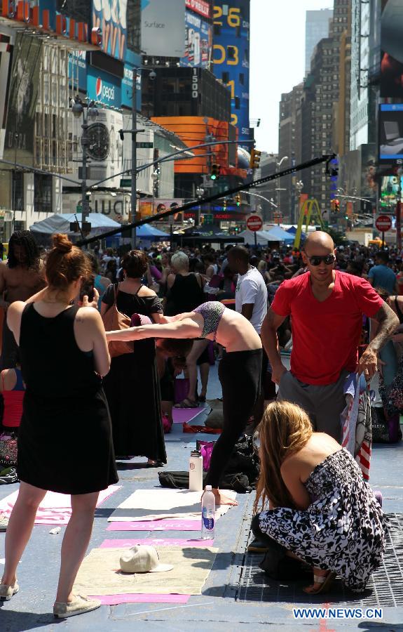 A Yoga enthusiast poses for photos after practicing yoga during the "Solstice in Times Square" event at Times Square in New York, the United States, June 21, 2013. Thousands of yoga enthusiasts came here to do yoga in celebration of the longest day of the year. (Xinhua/Cheng Li) 