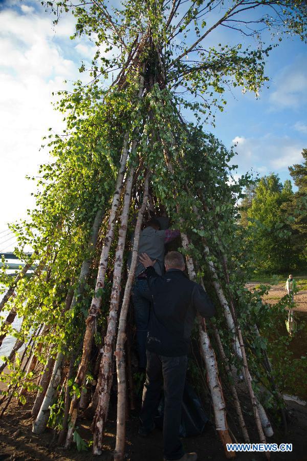 People prepare for the bonfire ceremony, celebrating summer solstice in Lapland, north Finland in the Arctic Circle, in June 21, 2013. As Lapland situates in the Arctic Circle, there happens polar day in Summer solstice. Night and day the midnight sun stays above the horizon.(Xinhua/Yan Ting) 