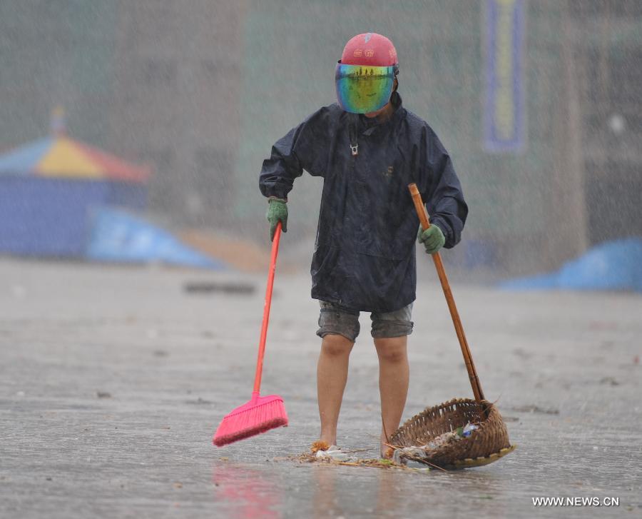 A cleaner works on the street in the rain in Qionghai City, south China's Hainan Province, June 22, 2013. Tropical storm "Bebinca" is estimated to arrive in south China's Guangdong Province on Saturday afternoon, the first to make landfall in China this year, the National Meteorological Center (NMC) said on Saturday. Affected by the tropical storm, coastal areas in Hainan and Guangdong provinces were battered by gales and torrential rain, the center reported. (Xinhua/Meng Zhongde)