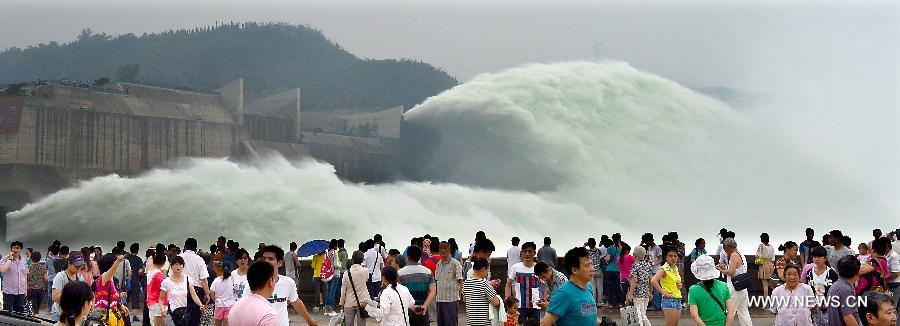 Tourists gather as water gushing out of the Xiaolangdi Reservoir on the Yellow River during a water and sediment regulating operation in Sanmenxia City of central China's Henan Province, June 22, 2013. The water and sediment regulating operation of Xiaolangdi Reservoir is conducted every year to clear out the mud and sand accumulated at the dam. (Xinhua/Wang Song)