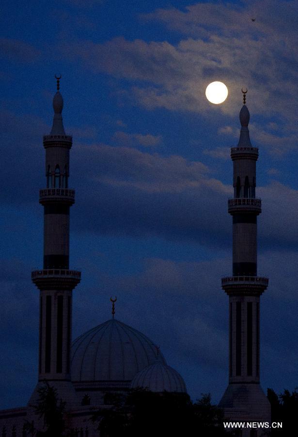 A super moon hangs in the sky over Rotterdam, the Netherlands, on June 22, 2013. On Saturday a perigee moon coincided with a full moon creating a "super moon" when it passed by the earth at its closest point in 2013. (Xinhua/Robin Utrecht)