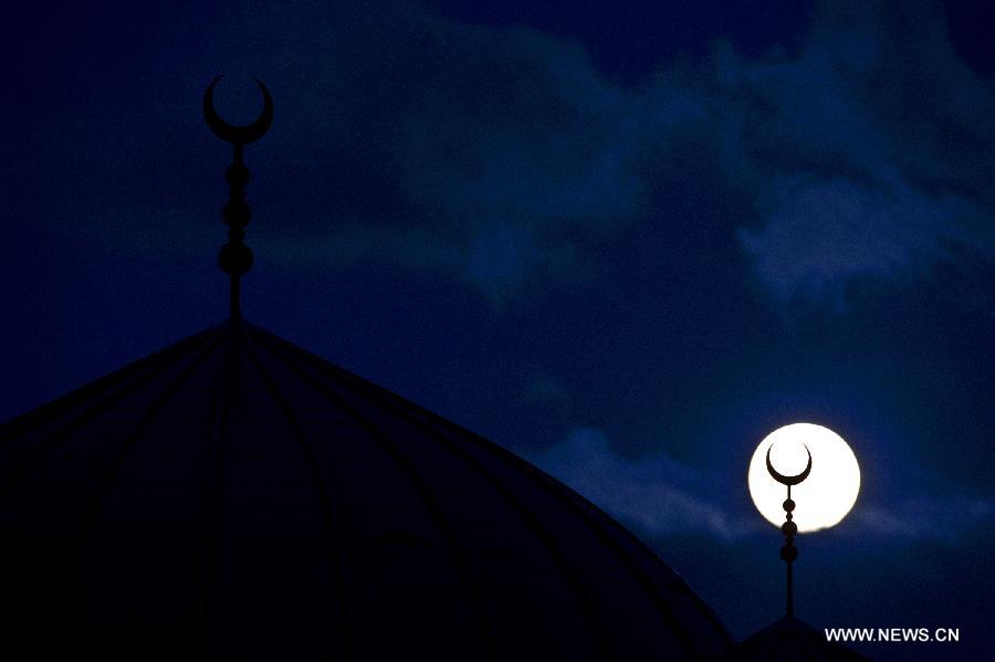 A super moon hangs in the sky over Rotterdam, the Netherlands, on June 22, 2013. On Saturday a perigee moon coincided with a full moon creating a "super moon" when it passed by the earth at its closest point in 2013. (Xinhua/Robin Utrecht)