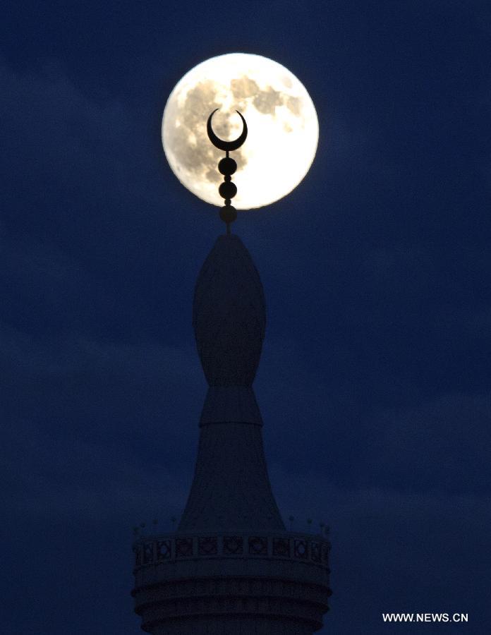 A super moon hangs in the sky over Rotterdam, the Netherlands, on June 22, 2013. On Saturday a perigee moon coincided with a full moon creating a "super moon" when it passed by the earth at its closest point in 2013. (Xinhua/Robin Utrecht) 