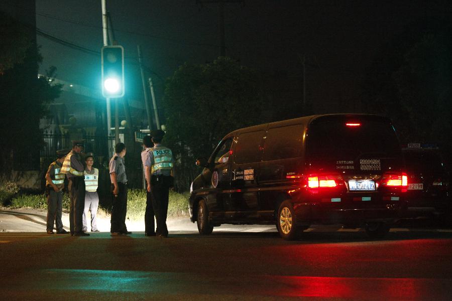 Security staff members and policemen guard at the murder site at a chemical factory in Baoshan District, east China's Shanghai Municipality, June 23, 2013. Police arrested late Saturday a 62-year-old man, surnamed Fan, who murdered six people, including four colleagues, a driver and a barracks guard in Shanghai. (Xinhua)