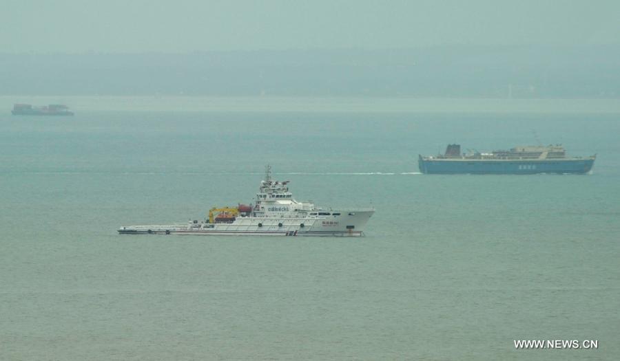 A rescue ship is still on duty to ensure safety at Qiongzhou Strait, Jun 23, 2013. Shipping services across Qiongzhou Strait, which links the Hainan island and the mainland, partly resumed Sunday morning as the impact of the tropical storm "Bebinca" weakened. (Xinhua/Zhao Yingquan) 