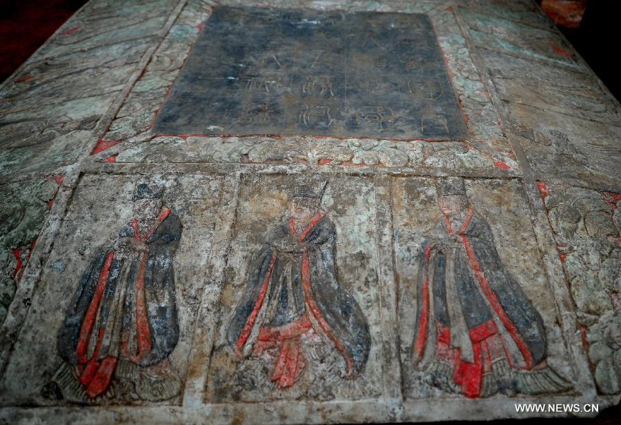 Photo taken on June 22, 2013 shows carvings on the gravestone at the archeological site of an ancient tomb in Fangshan District of Beijing, capital of China. A gravestone excavated from the tomb confirmed that the tomb was the final resting place of Liu Ji, a regional military governor of the Tang Dynasty (618-907), and his wife. Archaeologists have started a salvage excavation of the tumulus since August 2012, after it was accidentally discovered at a local construction site. Valuable cultural relics, including an exquisite stone coffin bed, were discovered. (Xinhua/Luo Xiaoguang)