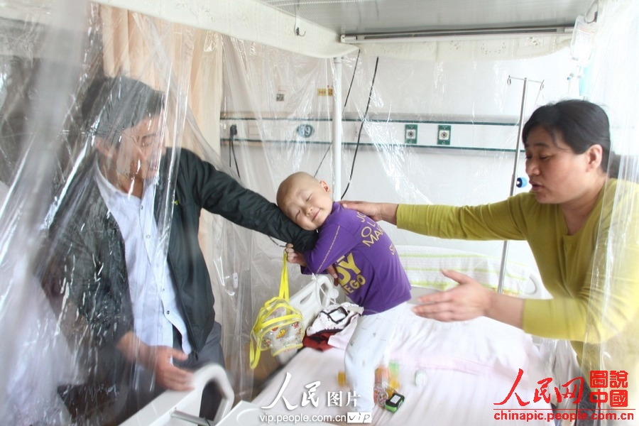 Yang holds his father tightly, refusing to let him go away. (Photo/vip.people.com.cn)