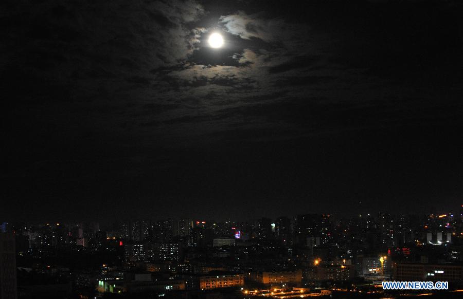 A full moon is seen surrounded by cloud in Haikou, capital of south China's Hainan Province, June 23, 2013. The moon looks 14 percent larger and 30 percent brighter than usual on Sunday. The scientific term for the phenomenon is "perigee moon", but it is also known as a "super moon". (Xinhua/Zhao Yingquan)