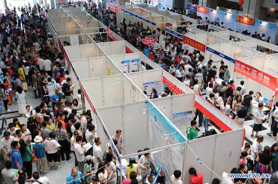 Students and parents attend a college enrollment consultation fair in Shijiazhuang, capital of north China's Hebei Province, June 23, 2013. The fair attracted representatives of nearly 300 colleges. Approximately 9.12 million people all over China took part in the National College Entrance Examination early June. (Xinhua/Wang Xiao)