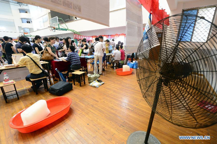 Students and parents attend a college enrollment consultation fair in Hangzhou, capital of east China's Zhejiang Province, June 23, 2013. The fair attracted representatives of nearly 200 colleges. Approximately 9.12 million people all over China took part in the National College Entrance Examination early June. (Xinhua/Li Zhong)