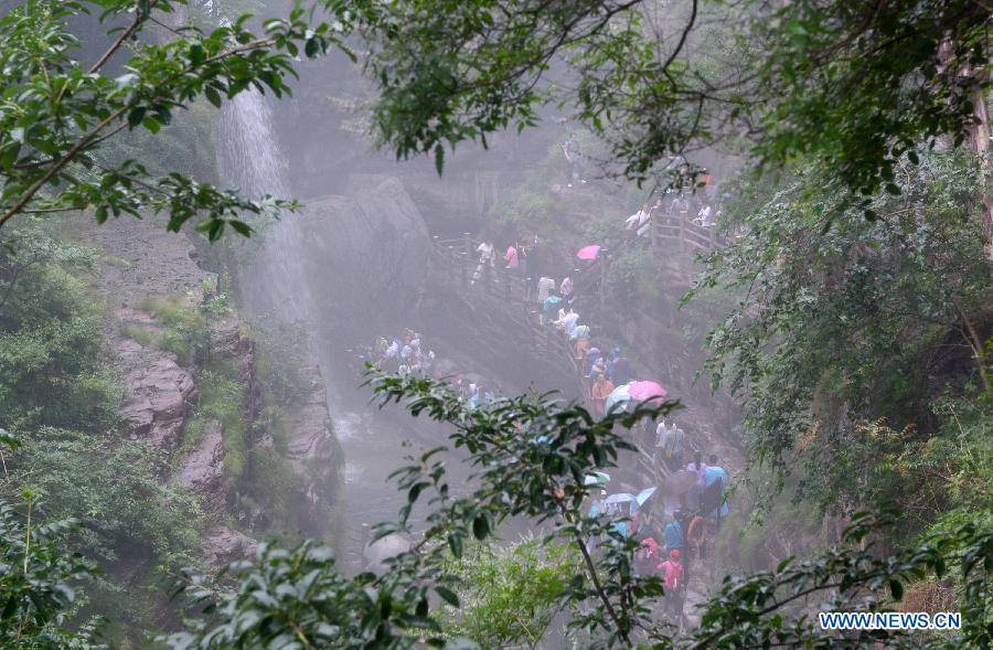 Tourists stroll in the Hongshixia scenic resort of Yuntai Mountain in Xiuwu County of central China's Henan Province, June 22, 2013. (Xinhua/Zhao Peng)