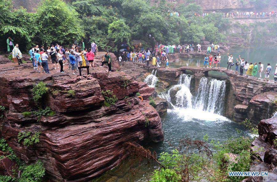 Tourists stroll in the Hongshixia scenic resort of Yuntai Mountain in Xiuwu County of central China's Henan Province, June 22, 2013. (Xinhua/Zhao Peng)