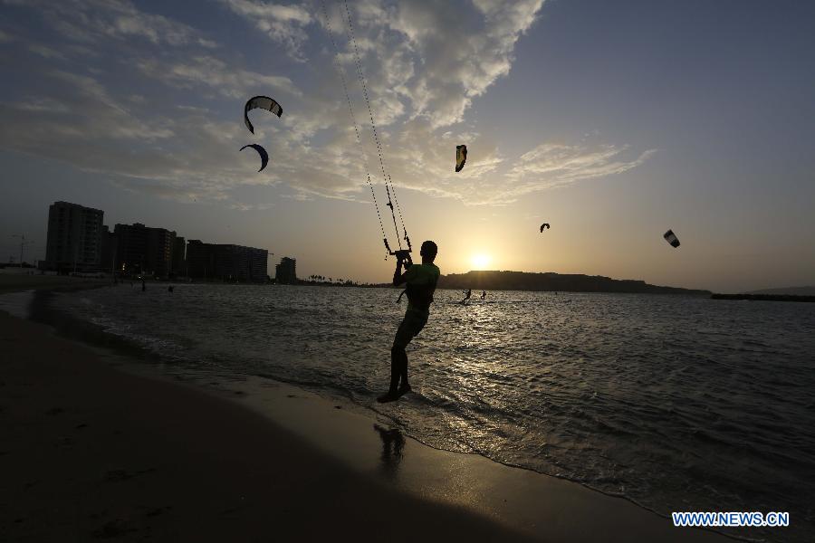 A kite surfer enjoys the sunset at Lido Beach in Lecheria City, Venezuela, on June 21, 2013. (Xinhua/Juan Carlos Hernandez)