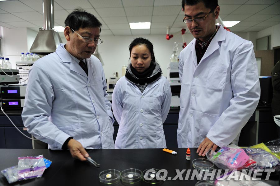 Lyu Changfu introduces how to identify camphor ball by using chemical reagent. (Xinhua/ Huang Junhui) 