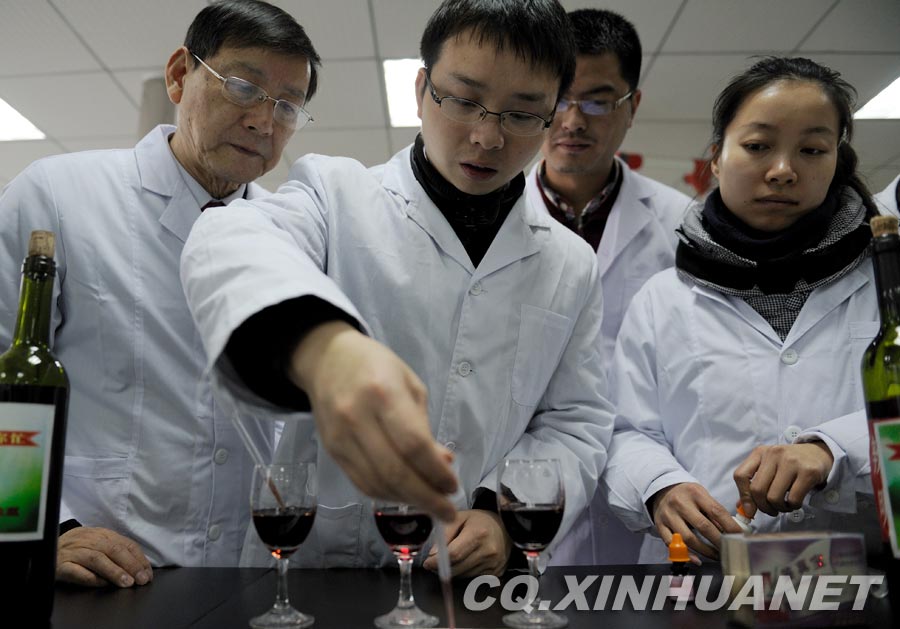 A staff member uses white vinegar to test black rice. White vinegar can turn real black rice from black to red. If the color doesn't change, it means the rice is dyed into black. (Xinhua/ Huang Junhui) 