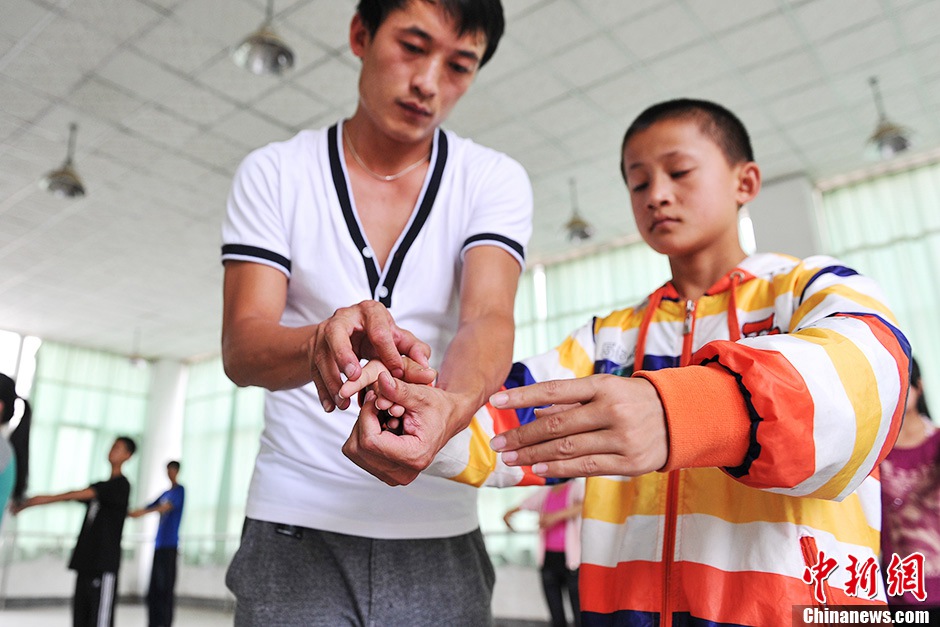 The teacher corrects the movements.(CNS/Ren Dong)