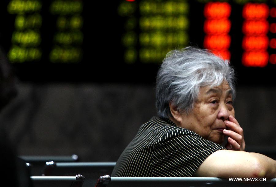 An investor is seen at a trading hall of a securities firm in Shanghai, east China, June 24, 2013. Chinese shares plunged on Monday and closed below a key psychological mark over worries about the liquidity crunch in the financial system and subdued strength in the world's second largest economy. The benchmark Shanghai Composite Index tumbled 5.3 percent to end at 1,963.24, the lowest point in nearly seven months, while the Shenzhen Component Index pummeled 6.73 percent to 7,588.52. (Xinhua/Pei Xin)