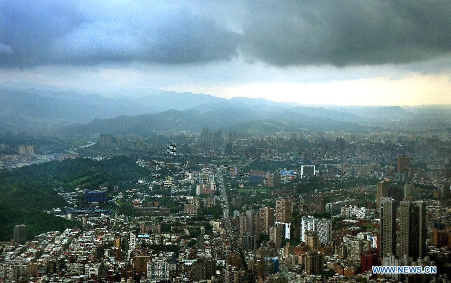 Photo taken on June 24, 2013 shows the western area of Taipei bathed in sunshine while the eastern area hit by rain in Taipei, southeast China's Taiwan. (Xinhua/Tao Ming)