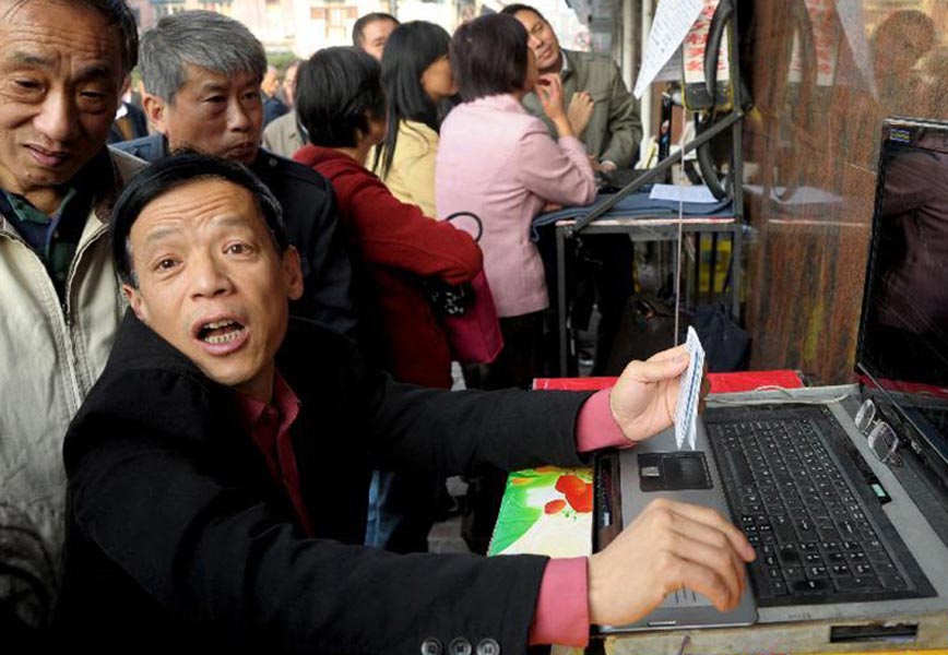 Stock investors discuss about stock price beside computers installed with self-developed stock software on Nov. 12, 2011. (Xinhua / Niu Yixin ) 