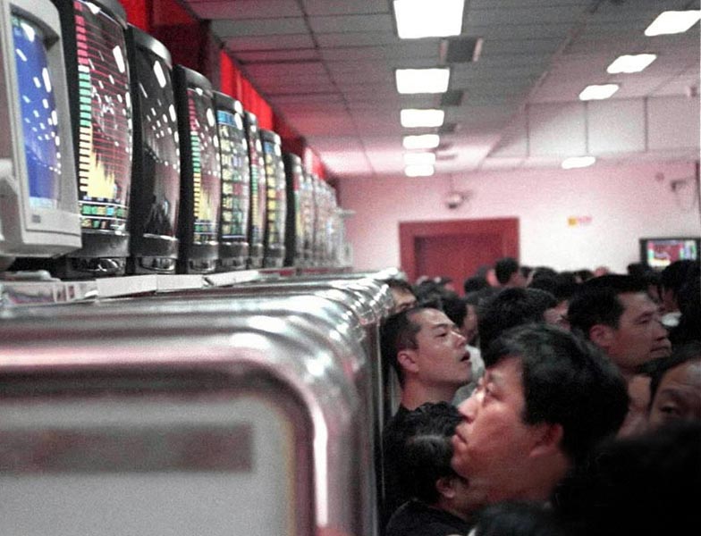 Stock investors check the stock price in a trading hall of China Southern Securities Co. Ltd in Beijing. China's Securities Law went into effect on July 1, 1999. It is the nation's first comprehensive securities legislation and signifies the legal basis for the sound and sustainable growth of China's security market.  (Xinhua/ Xu Xianhui)