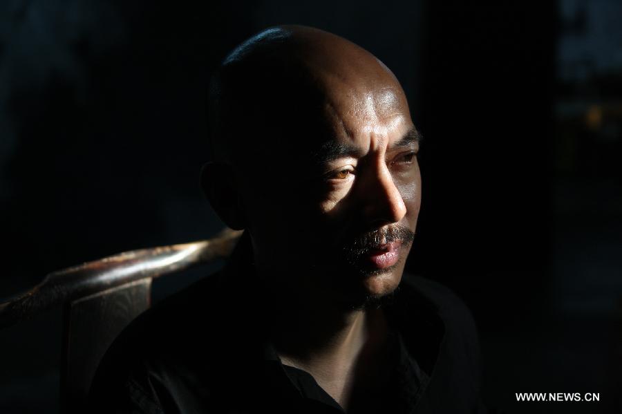 Zhang Fangbai, a 51-year-old painter, ponders at his studio in Beijing, capital of China, June 19, 2013. Zhang has specialized in painting eagles for a dozen of years. (Xinhua/Wu Xiaochu) 