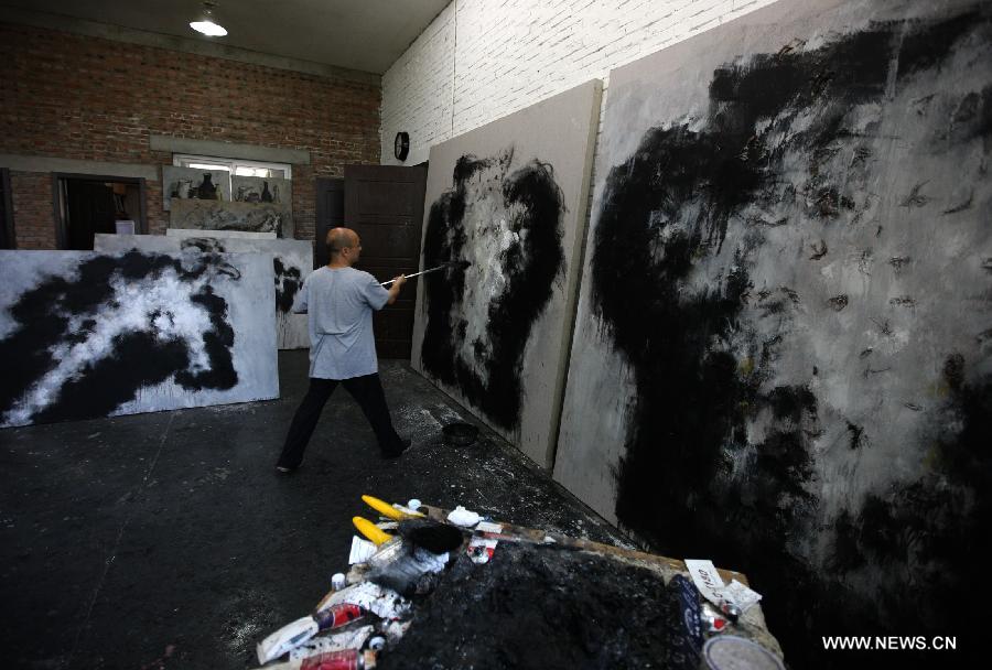 Zhang Fangbai, a 51-year-old painter, draws a picture at his studio in Beijing, capital of China, June 19, 2013. Zhang has specialized in painting eagles for a dozen of years. (Xinhua/Wu Xiaochu) 