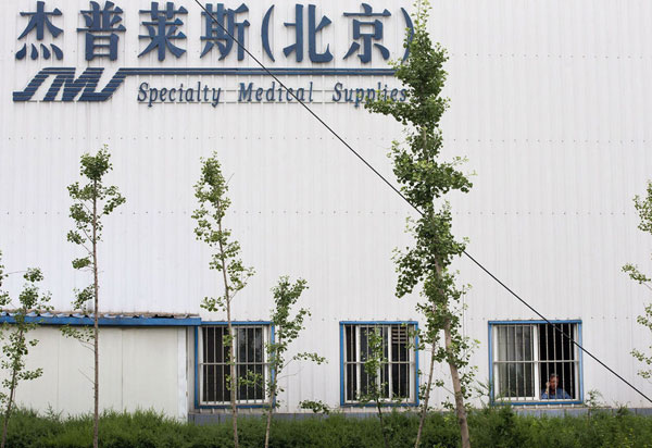 Chip Starnes, co-owner of Specialty Medical Supplies, looks out a window at the company's plant on the outskirts of Beijing, where he says he's been "kidnapped" by workers over a labor dispute, June 24, 2013. [Photo/Xinhua]