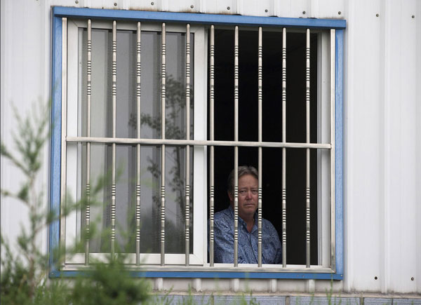 Chip Starnes, co-owner of Specialty Medical Supplies, looks out a window at the company's plant on the outskirts of Beijing, where he says he's been "kidnapped" by workers over a labor dispute, June 24, 2013. [Photo/Xinhua]