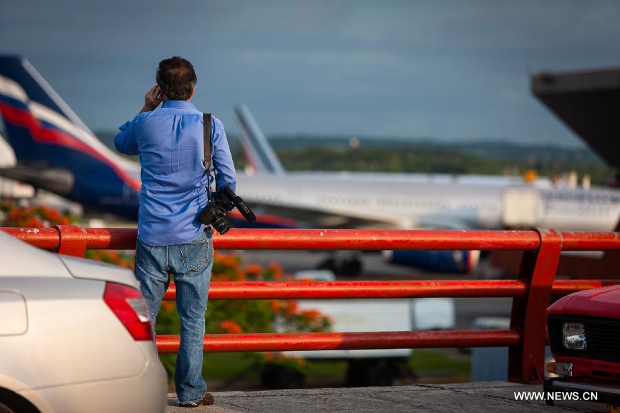 A reporter speaks on the mobile on seeing the flight SU150 from Moscow, Russia, at the Jose Marti airport in Havana, Cuba, June 24, 2013. Former U.S. intelligence contractor Edward Snowden did not show up at the flight. (Xinhua/Liu Bin)