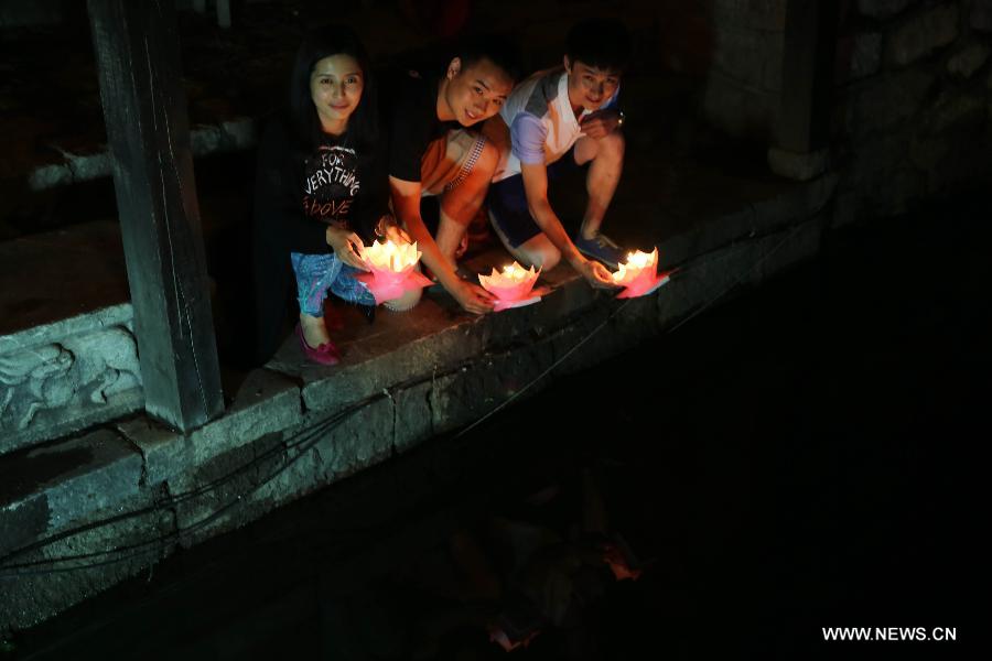 Tourists pray by floating river lanterns in the Old Town of Lijiang, southwest China's Yunnan Province, June 23, 2013. Lijiang has entered the peak tourism season with the coming of the summer. (Xinhua/Liang Zhiqiang) 