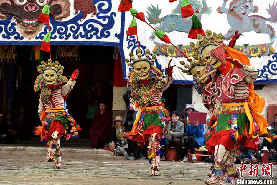 Lamas wearing masks perform "Qiang Mu" dance in Samye Monastery in Chanang County, Southwest China's Tibet Autonomous Region, June 24, 2013. "Qiang Mu," a religious dance of Tibetan Buddhism, is a well-established performing art form combining scripture chanting in perfect unison with music and dance, and performed in temples by lamas with solemn and splendid atmospheres. (CNS/Li Lin)