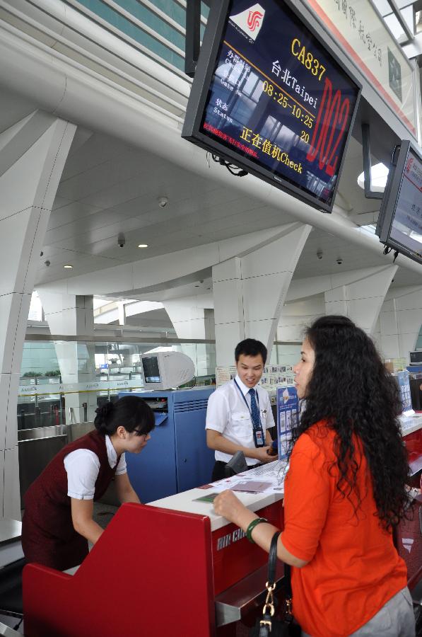 A passenger checks in before boarding an airplane to leave for Taipei, southeast China's Taiwan, in Hohhot, capital of north China's Inner Mongolia Autonomous Region, June 25, 2013. Air China opened the direct flight from Hohhot to Taipei on Tuesday. (Xinhua/Yu Jia)