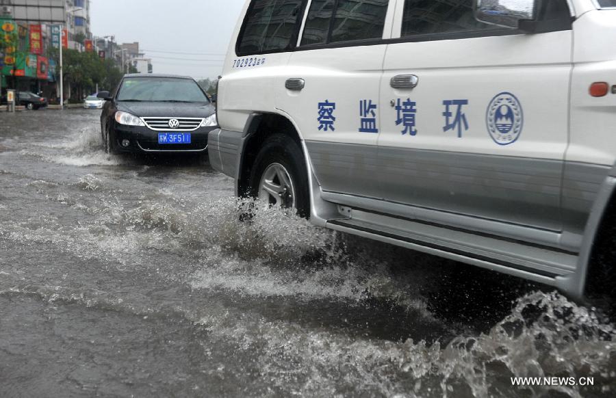 Cars move on the waterlogged road in Yangzhou City, east China's Jiangsu Province, June 25, 2013. Heavy rainfall hit many parts of Jiangsu on Tuesday. (Xinhua)