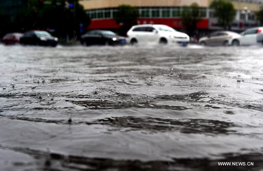 Cars move on the waterlogged road in Yangzhou City, east China's Jiangsu Province, June 25, 2013. Heavy rainfall hit many parts of Jiangsu on Tuesday. (Xinhua)