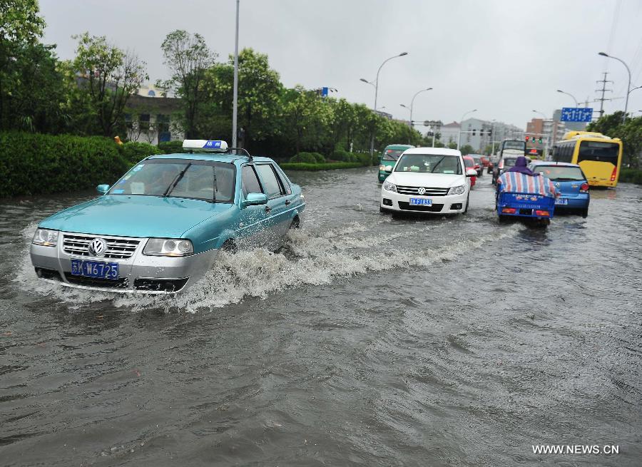 Cars move on the waterlogged road in Yangzhou City, east China's Jiangsu Province, June 25, 2013. Heavy rainfall hit many parts of Jiangsu on Tuesday. (Xinhua/Yang Yue)