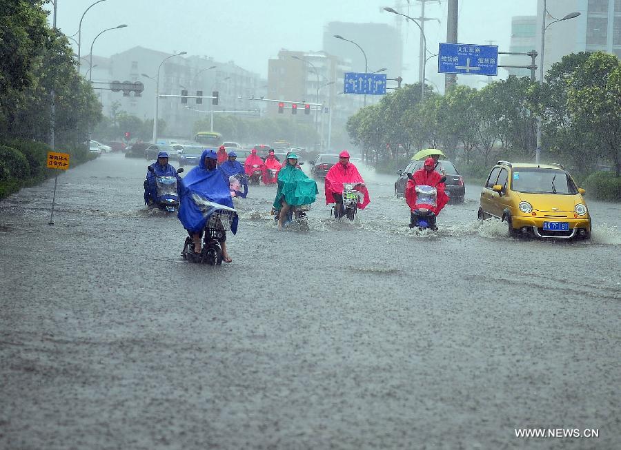 Citizens ride on the waterlogged road in Yangzhou City, east China's Jiangsu Province, June 25, 2013. Heavy rainfall hit many parts of Jiangsu on Tuesday. (Xinhua/Yang Yue)