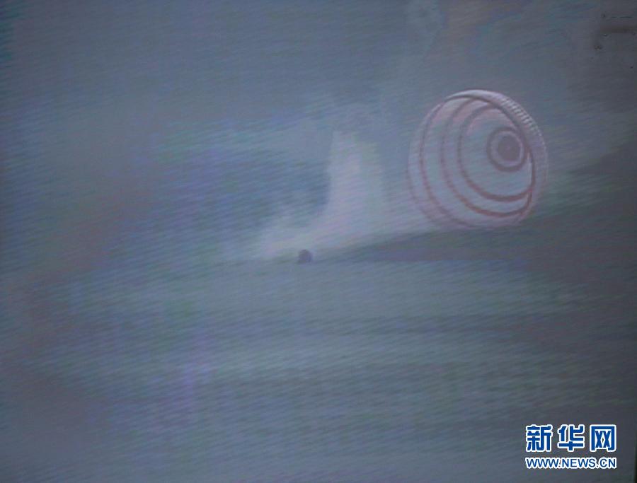 The screenshot shows the successful landing of the re-entry capsule of China's Shenzhou-10 spacecraft during its return to earth on June 26, 2013. (Xinhua) 