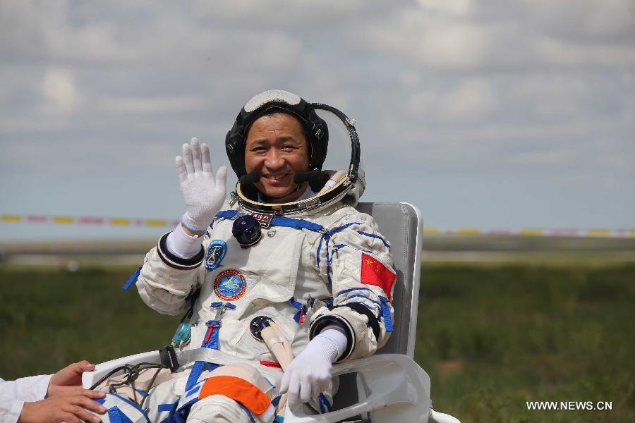 Astronaut Nie Haisheng waves to people after going out of the re-entry capsule of China's Shenzhou-10 spacecraft following its successful landing at the main landing site in north China's Inner Mongolia Autonomous Region on June 26, 2013. (Xinhua/Wang Jianmin)