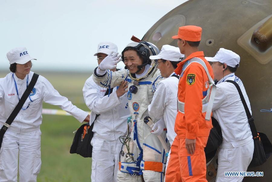 Astronaut Nie Haisheng waves to people after going out of the re-entry capsule of China's Shenzhou-10 spacecraft following its successful landing at the main landing site in north China's Inner Mongolia Autonomous Region on June 26, 2013. (Xinhua/Zhang Ling) 