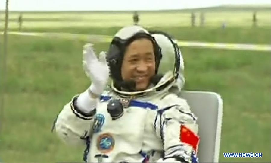 The video grab shows astronaut Nie Haisheng waves after getting out of the re-entry capsule of China's Shenzhou-10 spacecraft following its landing in north China's Inner Mongolia Autonomous Region on June 26, 2013. Commander-in-chief of China's manned space program Zhang Youxia has announced that the Shenzhou-10 mission was successful after the three crew members landed safely and left the spacecraft's re-entry module Wednesday morning. (Xinhua)