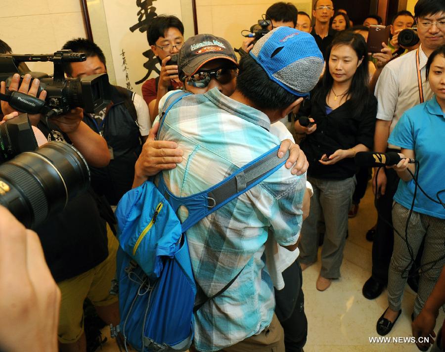 Survivor of a terror attack Zhang Jingchuan hugs his friend after arriving at the airport in Kunming, capital of southwest China's Yunnan Province, June 26, 2013. Two Chinese mountaineers were among the victims killed in a pre-dawn terror attack in Pakistan-administered Kashmir on June 23. (Xinhua/Qin Lang)  