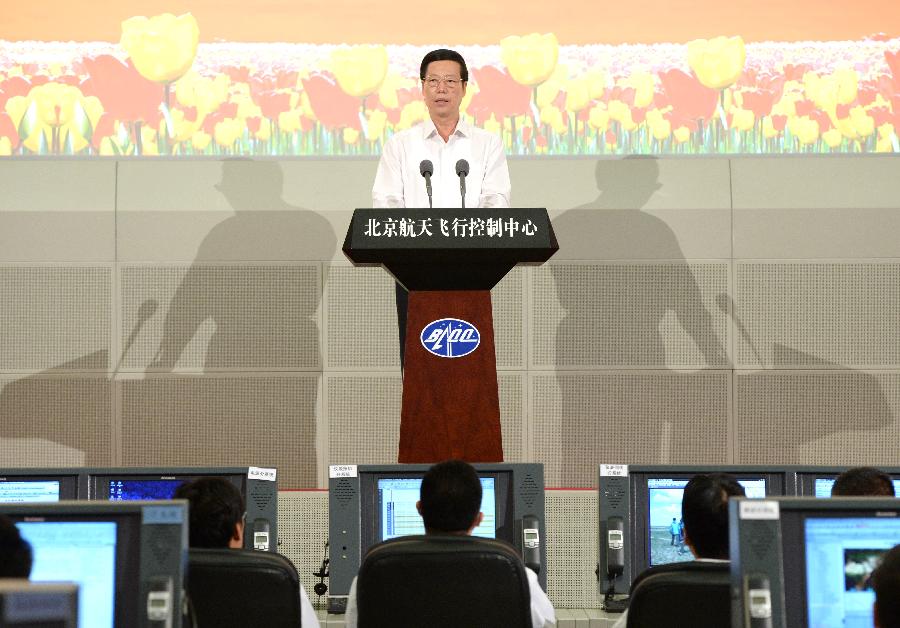 Chinese Vice Premier Zhang Gaoli watches the live broadcast of the return and recovery of Shenzhou-10 spacecraft and reads a congratulatory letter on behalf of the Central Committee of the Communist Party of China, the State Council and the Central Military Commission at the Beijing Aerospace Control Center in Beijing, capital of China, June 26, 2013. (Xinhua/Ma Zhancheng) 