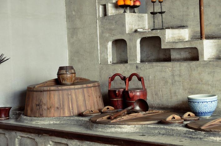 The cooking bench of Hu's family. The so-called Qixingzao (literally seven stars cooking bench) is commonly seen in wealthy families in southern China. A big copper kettle and rice buckets are placed on the cooking bench. There is a small room beside, for the cook on night shift to have a rest. (GMW.cn)