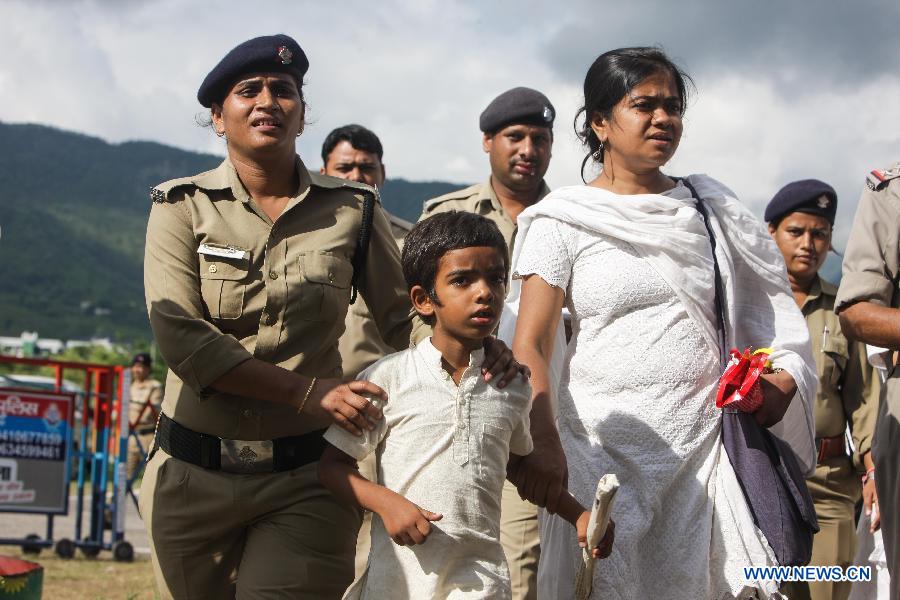 Rescuers escort flood-affected people at the airport in Dehradun, northern Indian state of Uttarakhand, June 26, 2013. There are still an estimated 7000 people stranded in the flood while authorities use military planes and helicopters in the rescue in flood-ravaged northern India. (Xinhua/Zheng Huansong)